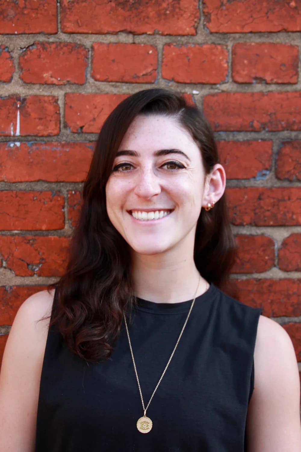 Hanna Bolaños smiling in front of a brick wall